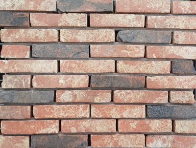 metselstenen waalformaat rood en zwart op gemetselde muur