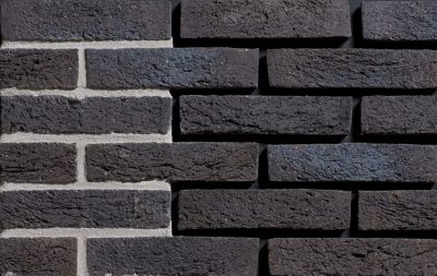 zwarte handvorm metselstenen in waalformaat op gemetselde muur